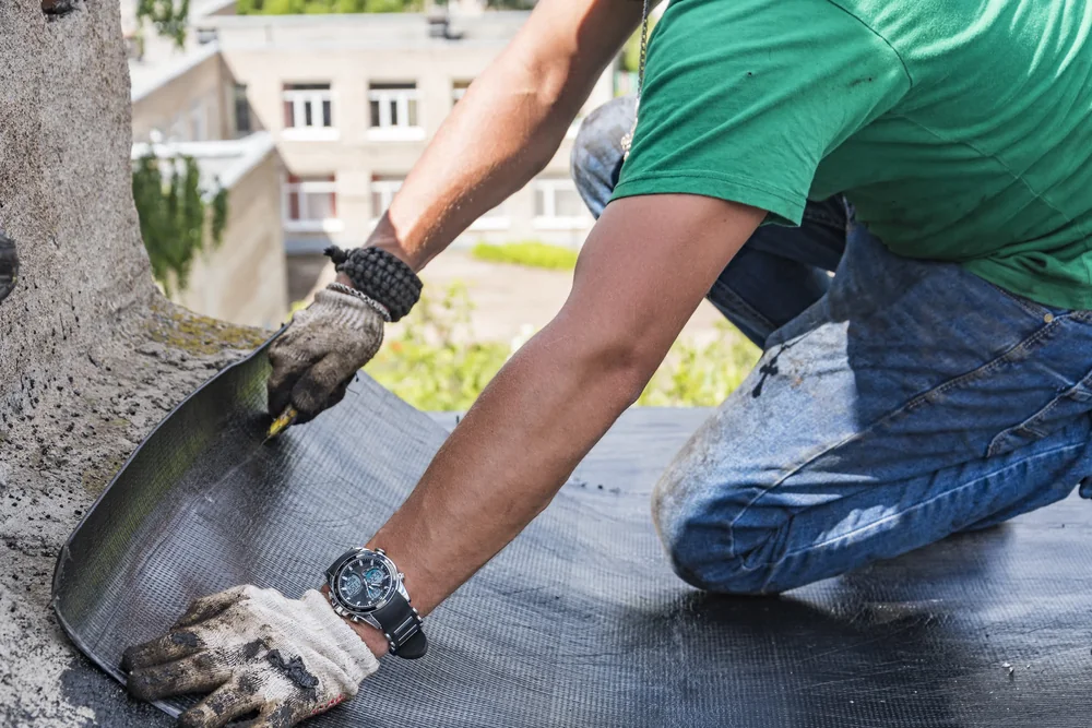 Worker carrying out roof repair work on a residential building